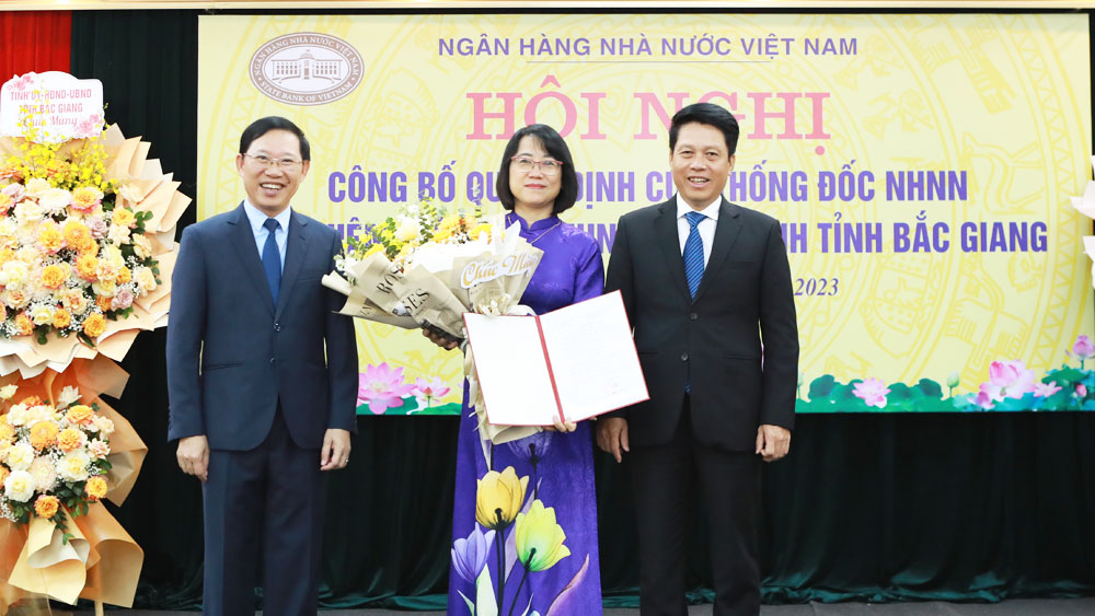 Phó Thống đốc NHNN Phạm Tiến Dũng (ngoài cùng bên phải) và Chủ tịch UBND tỉnh Bắc Giang Lê Ánh Dương trao Quyết định và tặng hoa chúc mừng đồng chí Lê Thị Hoàng Hà